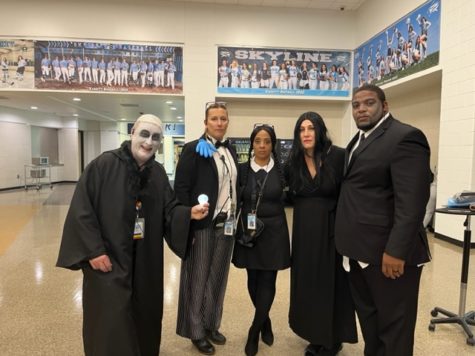 Skyline Administrators Pause for Halloween Photo: McElmeel as Uncle Fester, Sissoko as Gomez (with Hand), Patterson as Wednesday, Elmore as Morticia, and Criswell as Herman Munster. Credit: Casey Elmore.