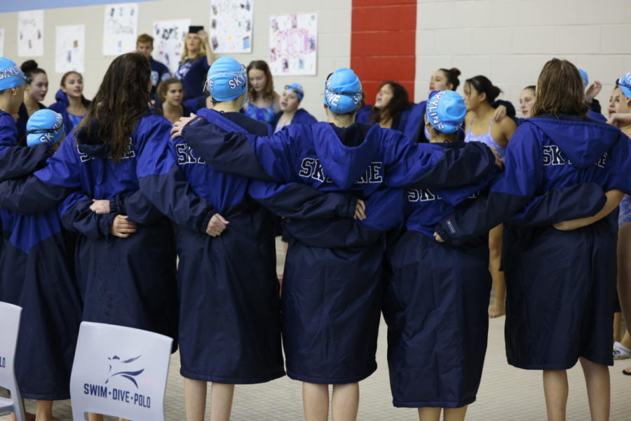 The Girls Swim and Dive Team forms a circle before a meet. Credit: Jae Lee.