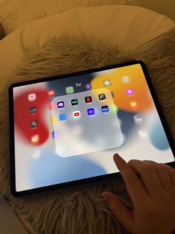 Elena (23) reaches to open Hulu on her iPad.