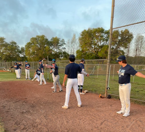 Members of the varsity baseball team warming up during a practice
