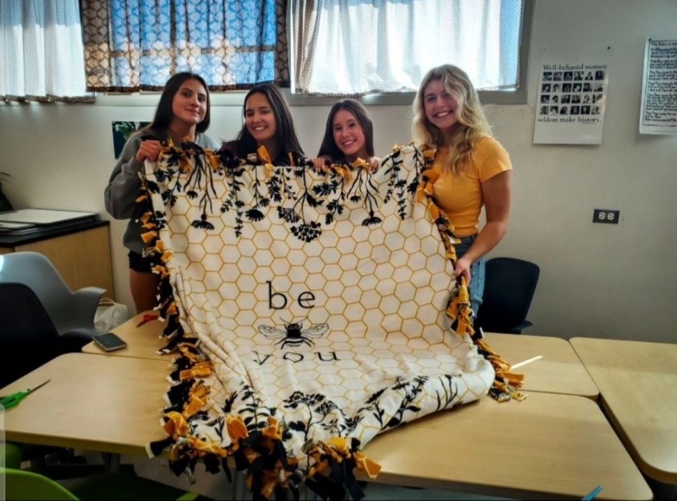 Anika Vaitkevicius (25), Abby Yuan (25), Elle Wong (25) and Riley Howe (25) holding up a blanket they made during their Naptime Ninjas meeting. Photo: Shayan Khailany (25)