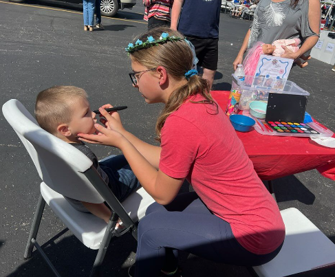 Olivia Szczepanski ('28) painting a kid's face at the Polish-American Heritage Festival.