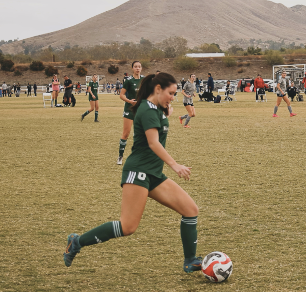 Elle Wong ('25) kicks soccer ball towards the goal. 