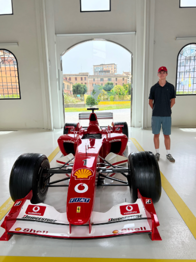 Rider Recla stands by an F1 car in Italy.