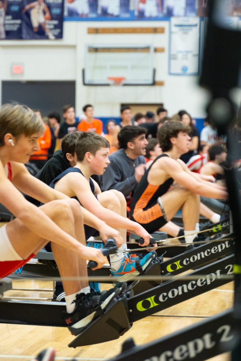 Crew teams on the ergs during a challenging race in the Skyline gym. 