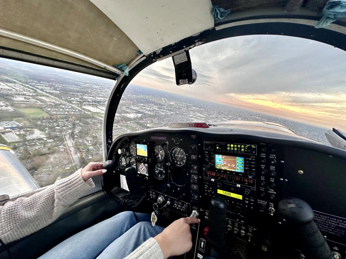 Zoie Reichert ('26) flying a plane over Ann Arbor.