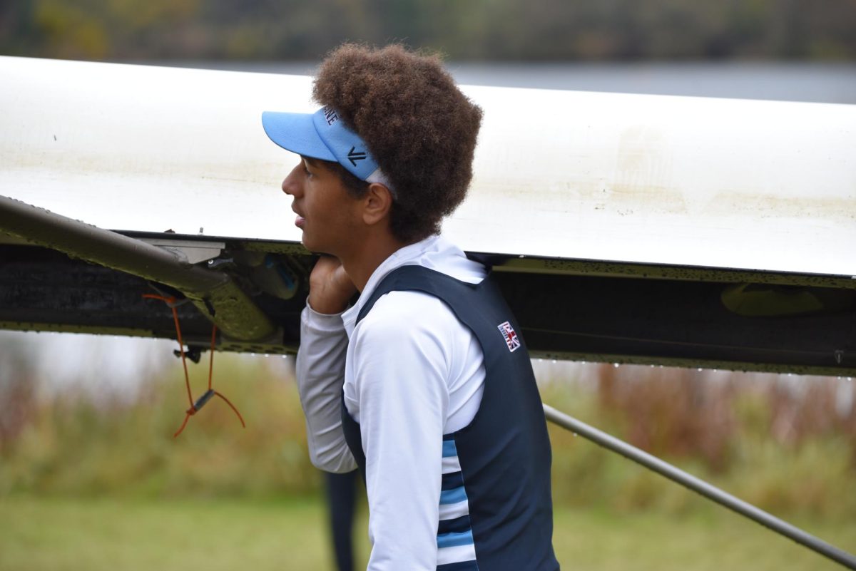 Rower Seth Merges (‘27) carrying his boat back to the trailer at Artic regatta with teammates. 