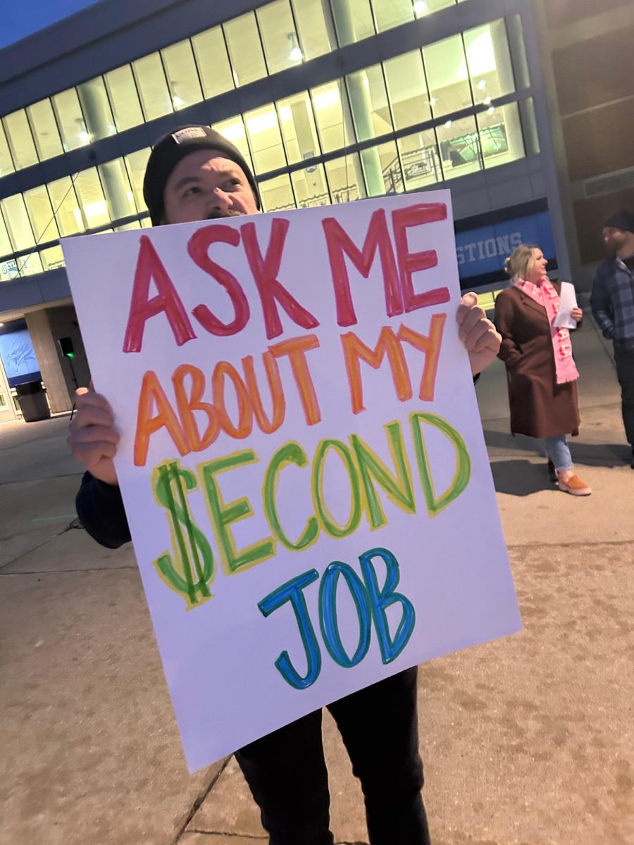 Skyline teacher holding up sign at an early informational picket.