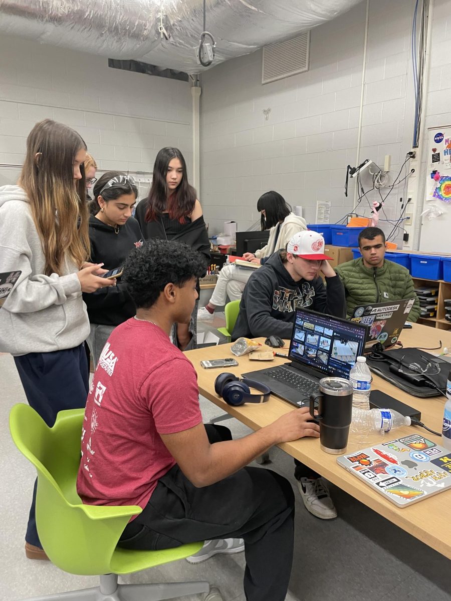 Members of the Skyline Robotics design team researching and discussing how the robot will climb up a cage.