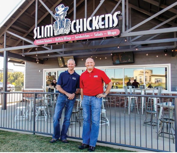 The owners, Tom Gordon and Greg Smart, standing in front of their restaurant Slim Chickens.