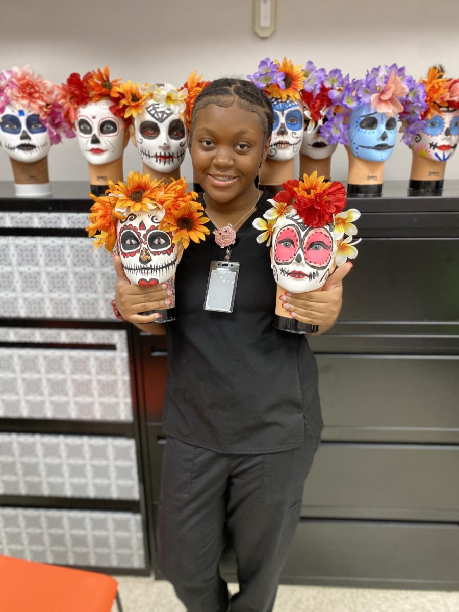 Johnnae Foster holding day of the dead masks.