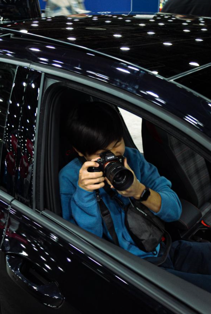 Joowon Lee photographing cars at the Detroit Auto Show.