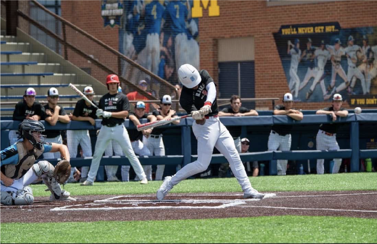 Donnie Hill ('25) swinging at a curveball at the Michigan Stadium.