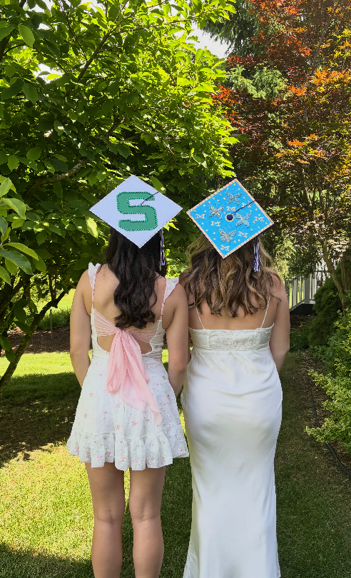 Friends pose in their freshly decorated caps before graduation.