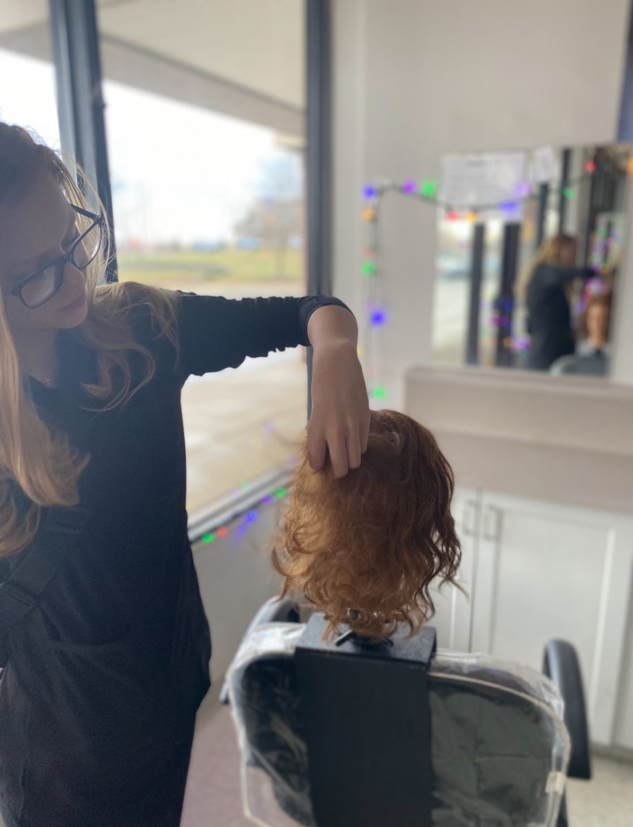 Carsyn working on a wavy hairstyle in cosmetology.