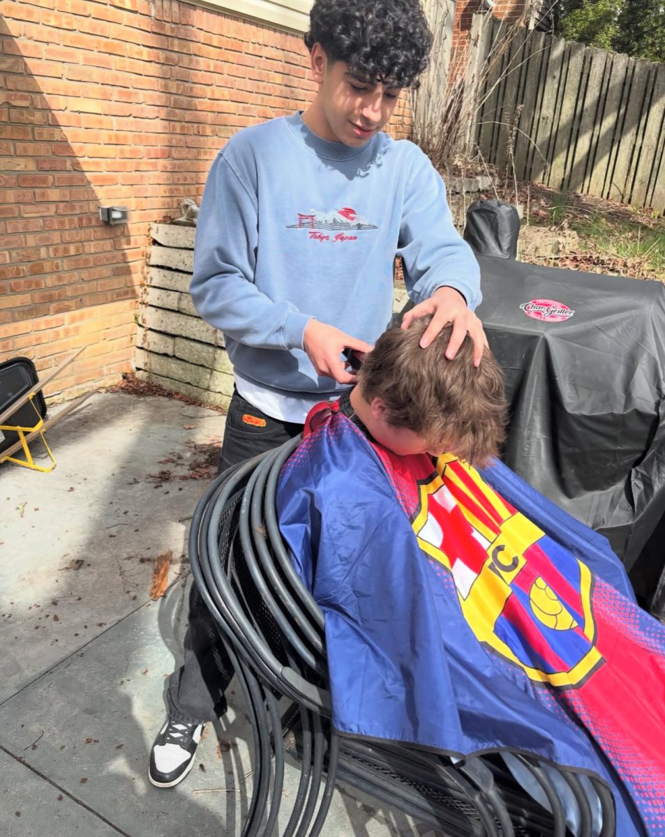 Khudr cuts a friends hair. 