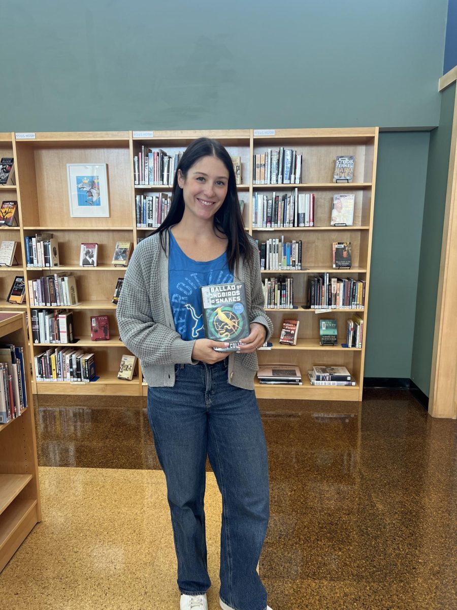 Ms. Szurek holds up a book. 