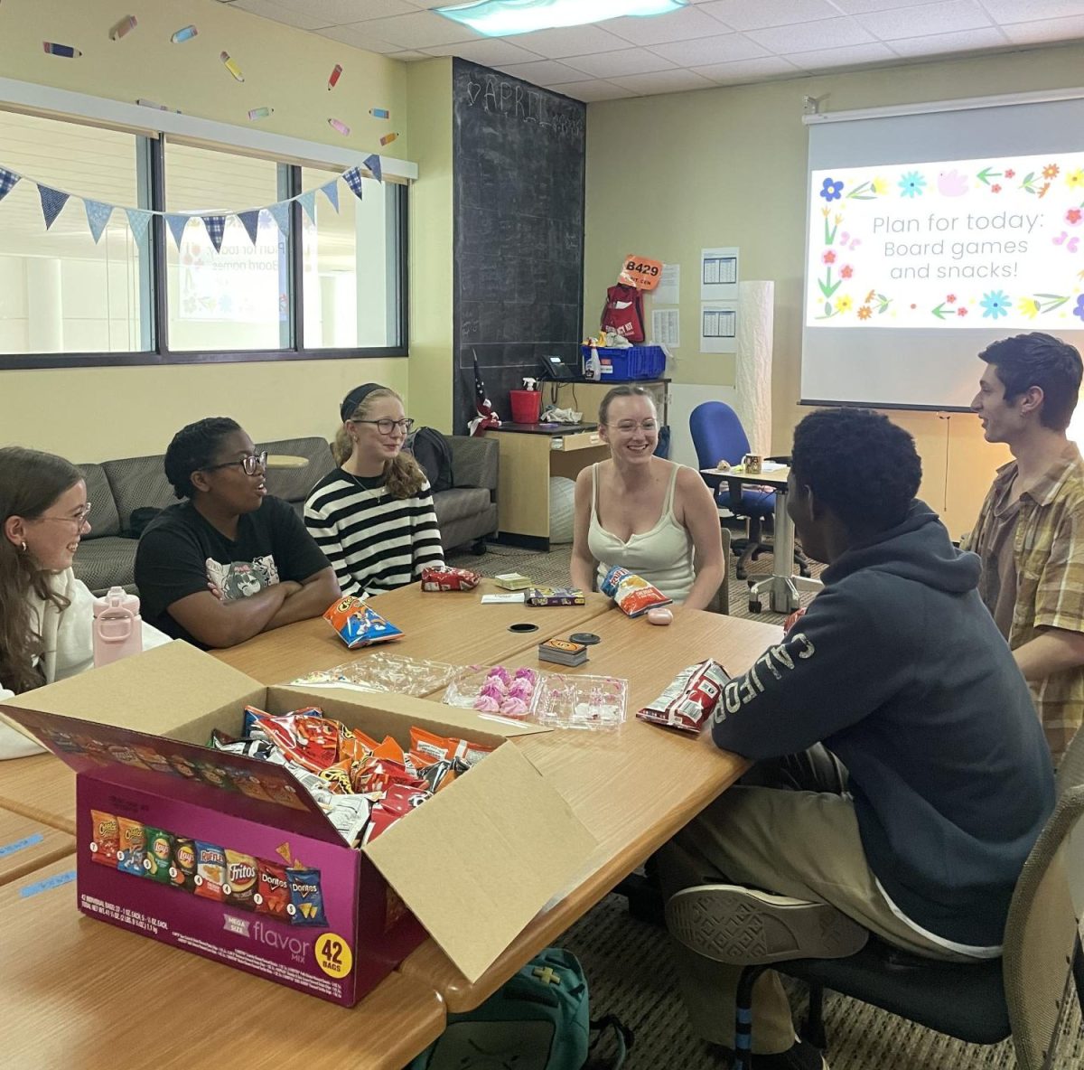 Positivity Club members gather to snack, chat, and play Uno Flip.