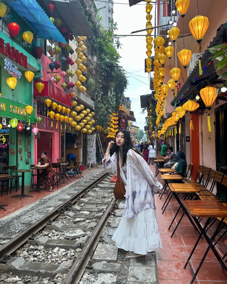 Alice Jeong posing at Hanol train street in Vietnam