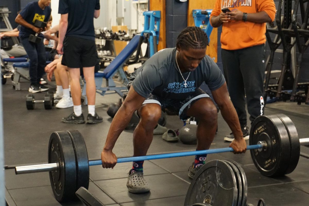 Harshaw demonstrating how to do a deadlift during a lifting session.