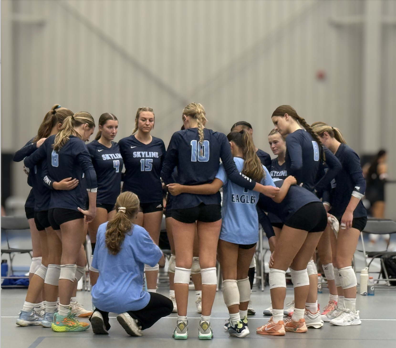 The Eagles huddle around their coach during a timeout, listening closely to the game plan.
