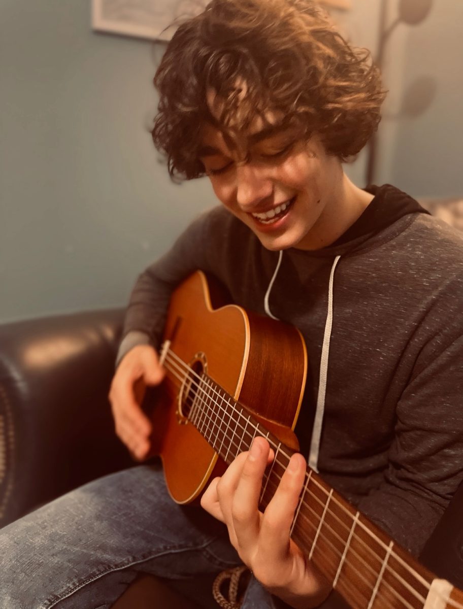 Owen DeVries ('27) playing guitar.