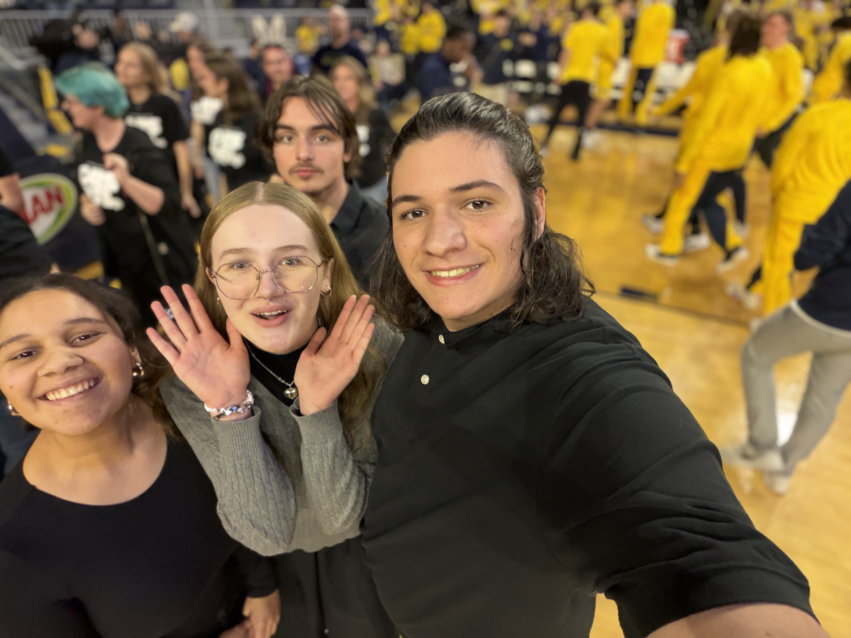 Mason Ruhfel ('27), Eleanor Wing ('26), Shekinah Chikosi ('28), and Louis Grengs ('27) getting ready to sing at the Michigan vs. Villanova basketball game.