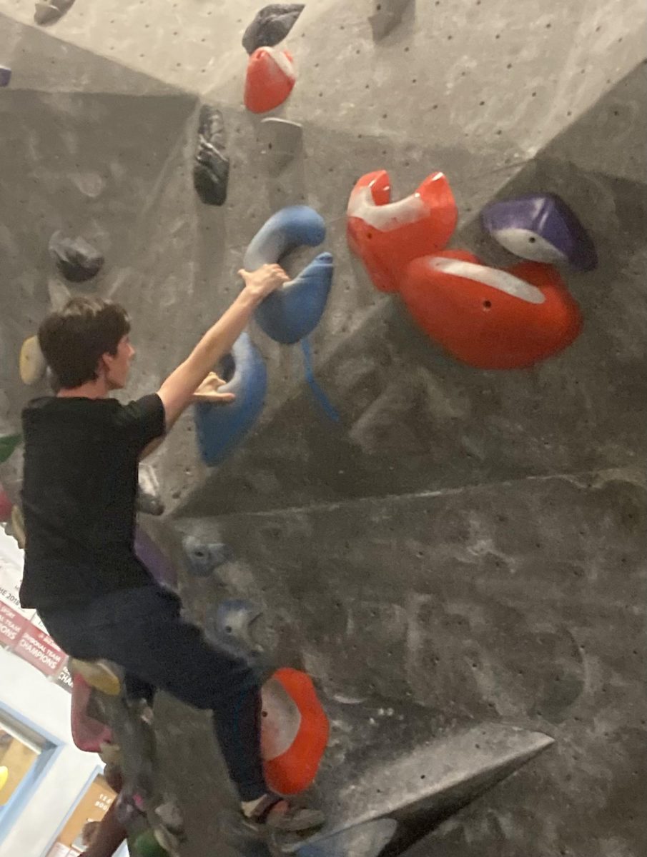 Elliot Scully ('26) grabs the final hold of a route.