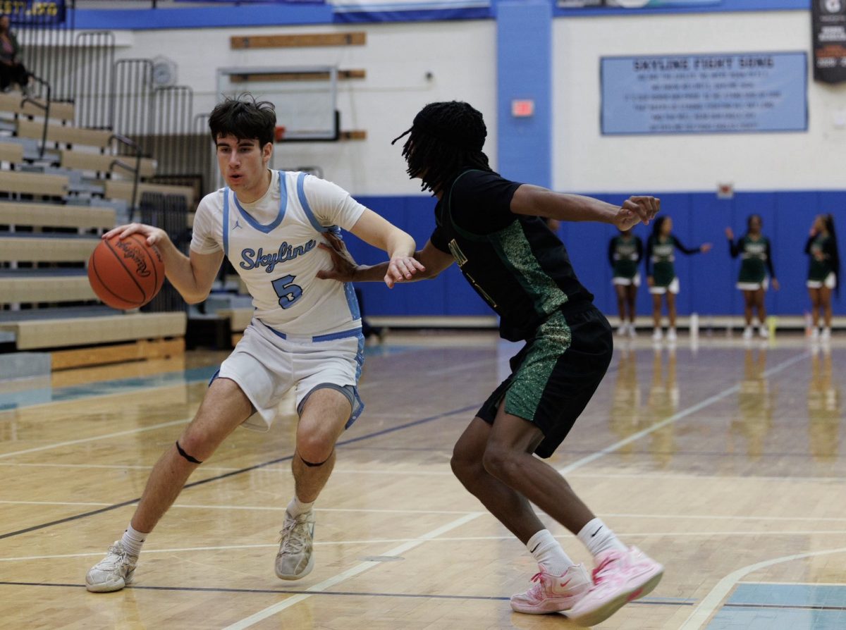 Owen Peterson ('26) dribbling towards the hoop against Huron