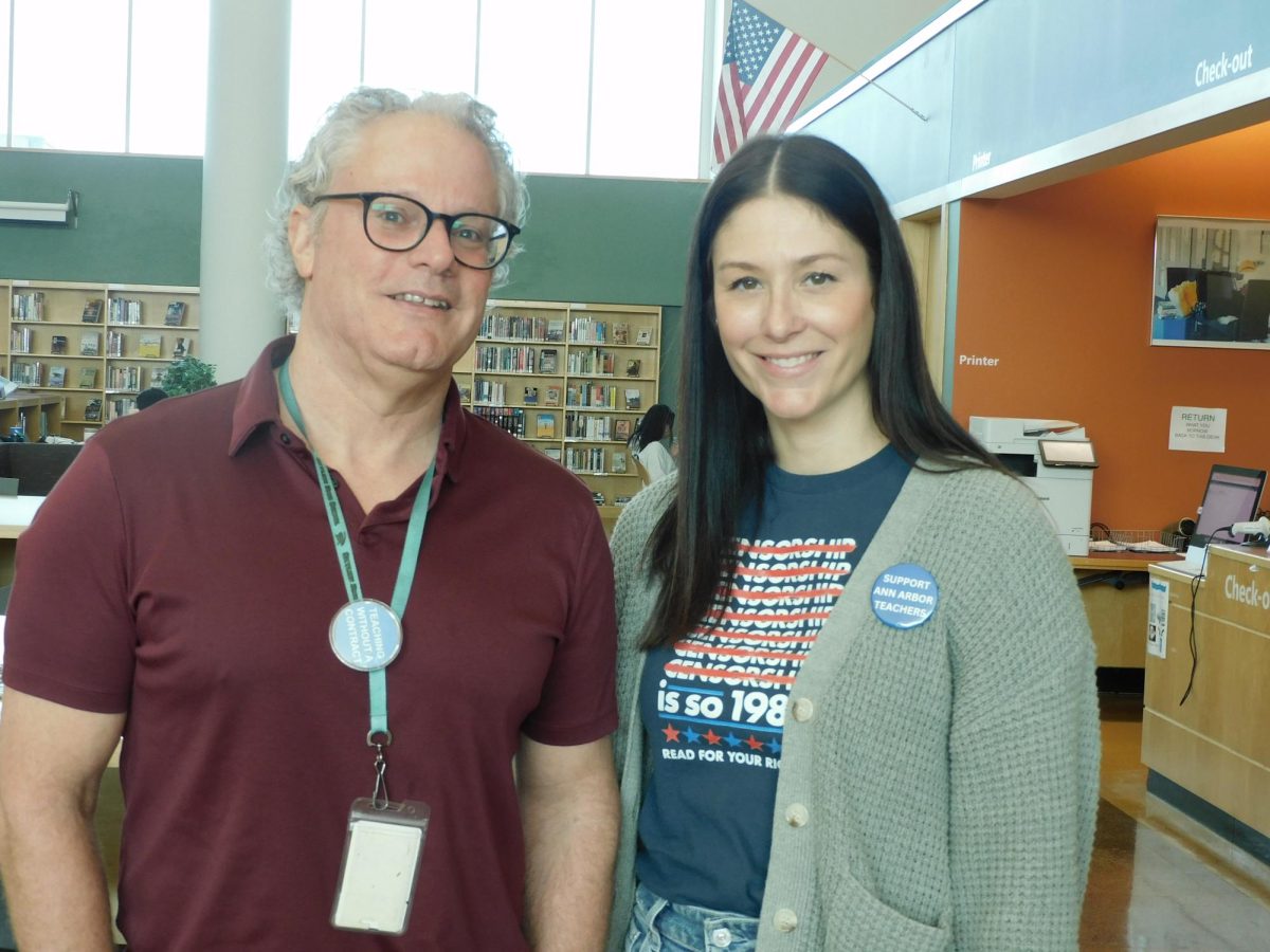 Skyline Staff members Collin Ganio and Lindsey Szurek show support for Ann Arbor teachers by wearing union support pins in the Skyline library following the rejection of the tentative agreement between the Ann Arbor Education Association and the district.
