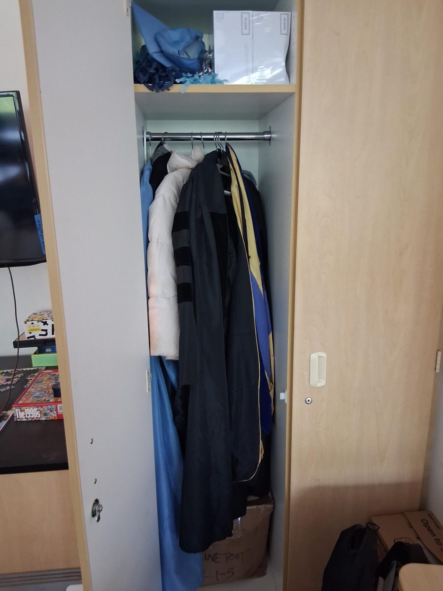 A teacher's graduation gown, collecting dust in the closet.